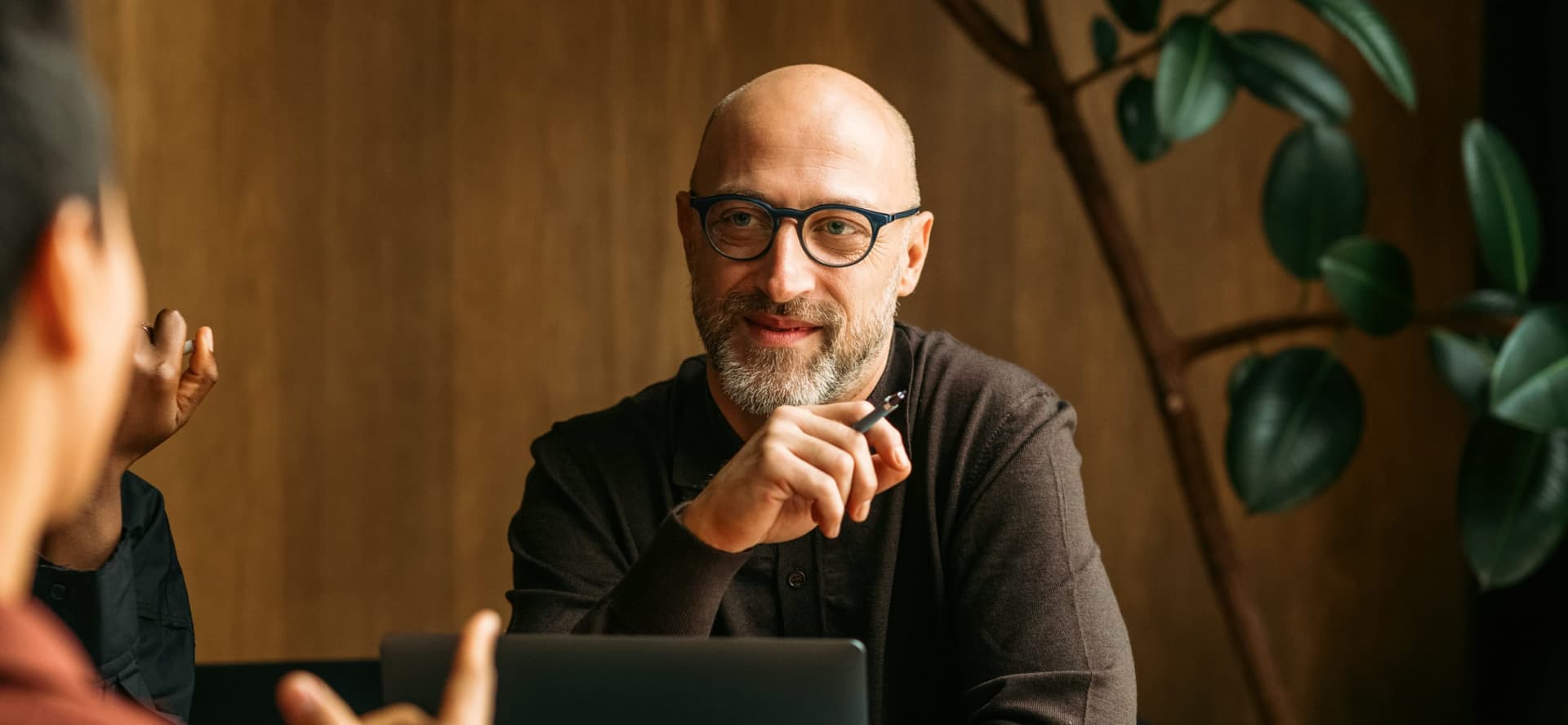 middle aged man talking with team in a conference room