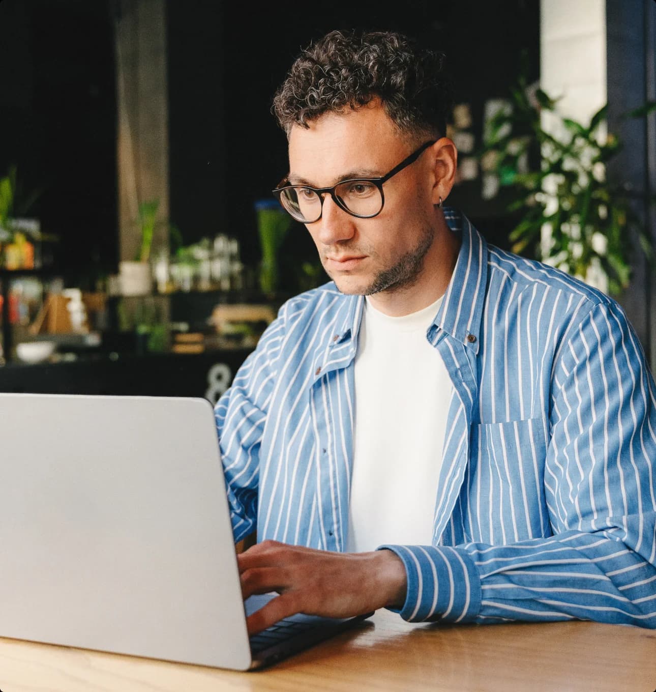 man sitting in a coffee shop working on a computer