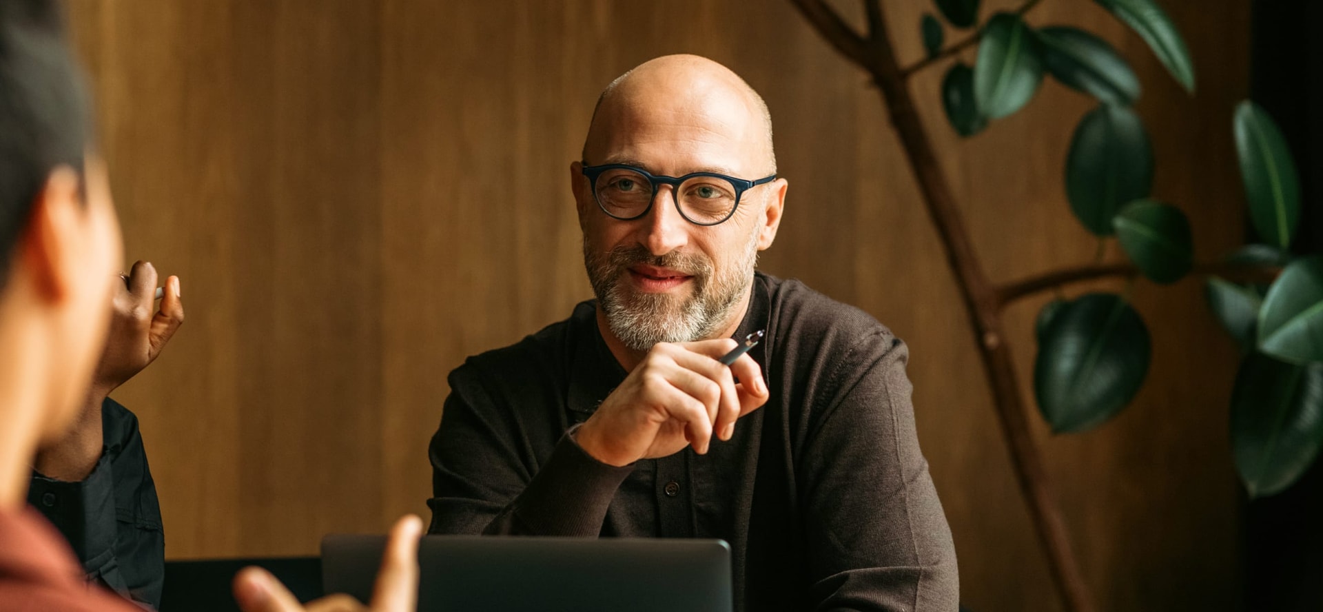 middle aged man talking with team in a conference room