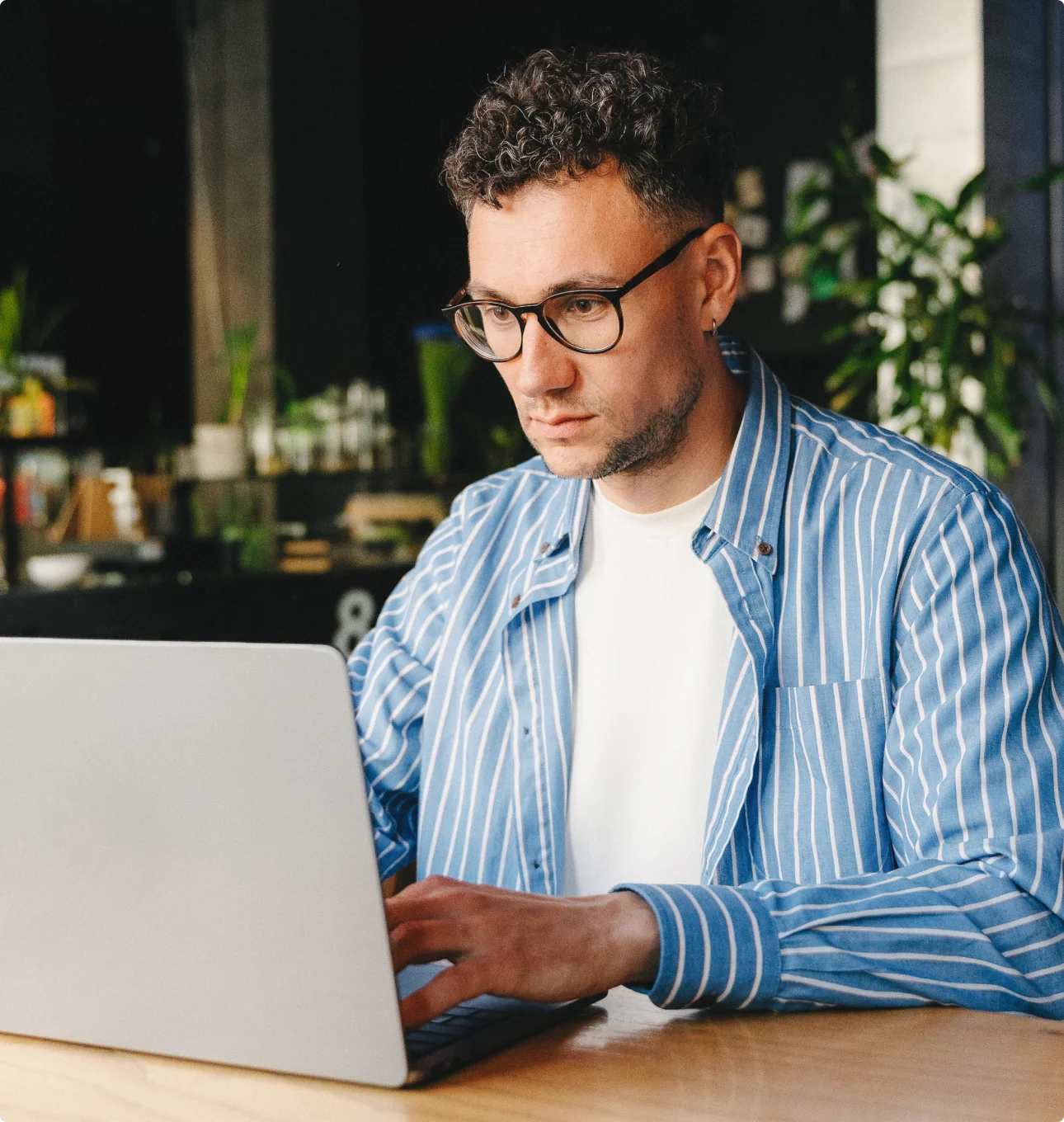 man sitting in a coffee shop working on a computer